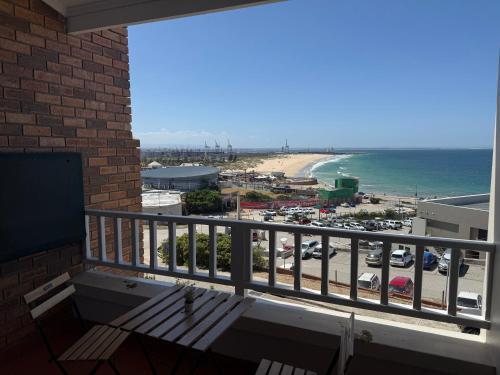 a balcony with a bench and a view of the beach at Beachfront Luxury Apartment Sea View & Free Parking in Gqeberha