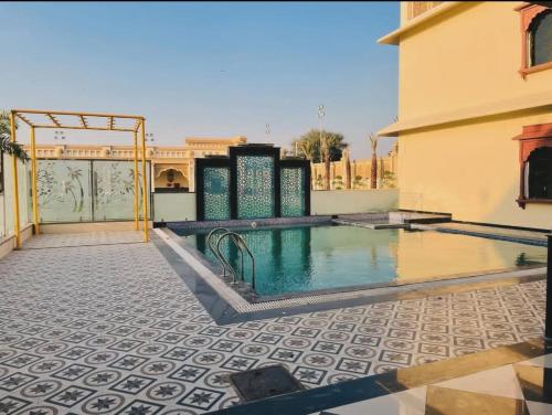 een zwembad op de binnenplaats van een gebouw bij Pink Mahal Hotel & Resort in Jaipur