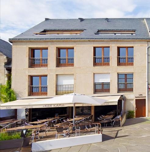a building with tables and umbrellas in front of it at Bien-être & Panorama - Les Gîtes de la Côte d'Amour in Le Croisic