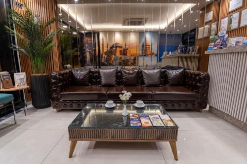 ein Wohnzimmer mit einem Ledersofa und einem Couchtisch in der Unterkunft The Omiya Hotel in Istanbul