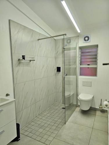 a bathroom with a shower and a toilet at Chakas Rock Chalet 45 in Ballito