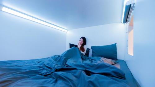 Una cama o camas en una habitación de Bobopod Juanda, Jakarta