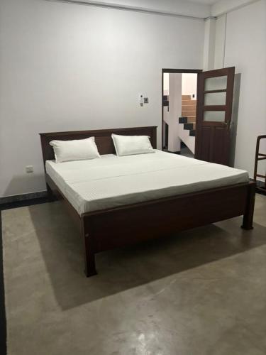 Villa Kia Ora في غالي: سرير في غرفة نوم مع إطار سرير خشبي