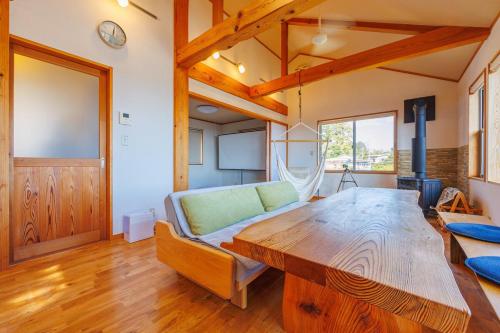 a living room with a wooden table and a couch at きらぼしの里 大室高原 in Ito