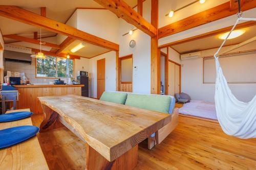 a living room with a wooden table and a hammock at きらぼしの里 大室高原 in Ito