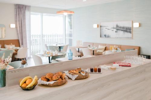 a table with baskets of food on it in a restaurant at Zenitude Quality Aparthotel Quiberon in Quiberon
