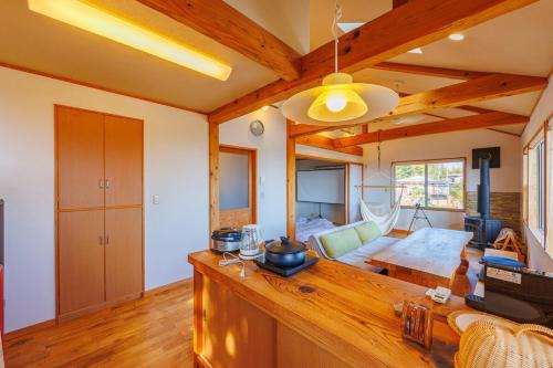 a living room with wooden ceilings and a table at きらぼしの里 大室高原 in Ito