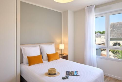 Un dormitorio con una cama con una ventana grande. en Quality Suites Saumur, en Saumur