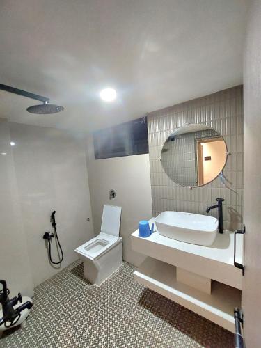 a bathroom with a sink and a toilet and a mirror at Hotel Neelam in Amrāvati