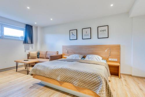 Alte Teestube Schmidt 59 Links في نورديرني: غرفة نوم بها سرير كبير وأريكة