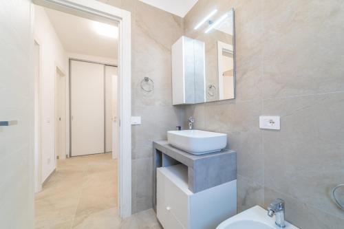 a bathroom with a sink and a toilet and a mirror at Brorent A & L apartment T in Golfo Aranci