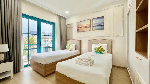 a hotel room with two beds and a window at Hamster Villa in Bình Tú