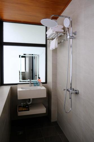 a bathroom with a sink and a shower with a mirror at Casa de Anna in Kỳ Vĩ