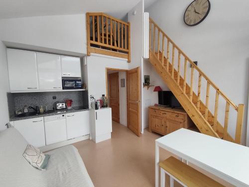 una cucina con mobili bianchi e un orologio sul muro di Les Eterlous N44 2P6 a Morillon