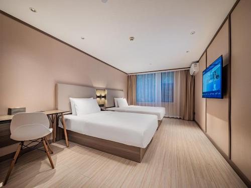 een hotelkamer met twee bedden en een tv bij Hanting Hotel Chengdu Tianfu Square Subway Station in Chengdu