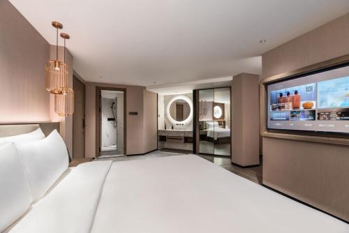 a large bedroom with a large bed and a large television at Crystal Orange Shanghai Safari Park Hotel in Shanghai