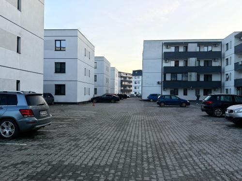 a parking lot with cars parked in front of buildings at Vanilla Studio Apartment 2 in Timişoara