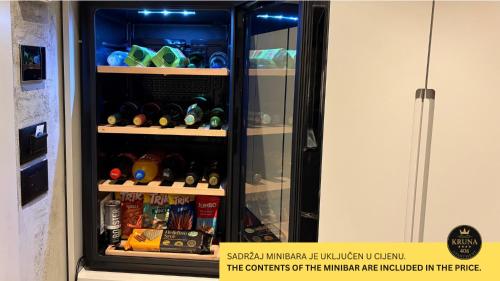 a refrigerator filled with lots of different types of alcohol at KRUNA 406 Apartment in Becici