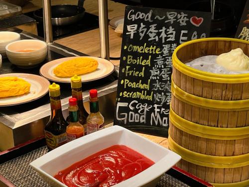 a table with plates of food and bottles of sauce at Four Points by Sheraton Guangzhou Financial City, Tianhe in Guangzhou