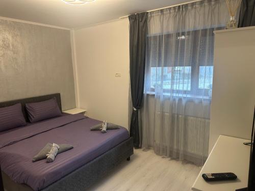 a bedroom with a purple bed and a window at Central VIP in Craiova