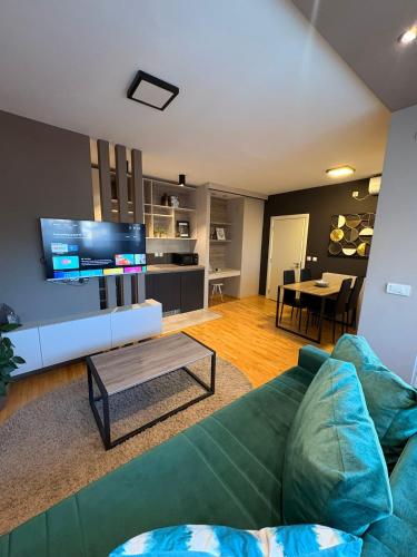 a living room with a green couch and a table at NAR Royalton Deluxe Apartment #74 in Niš