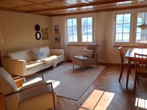 a living room with a couch and a table at Mattishüüsli - Chalet with a little garden in Luchsingen
