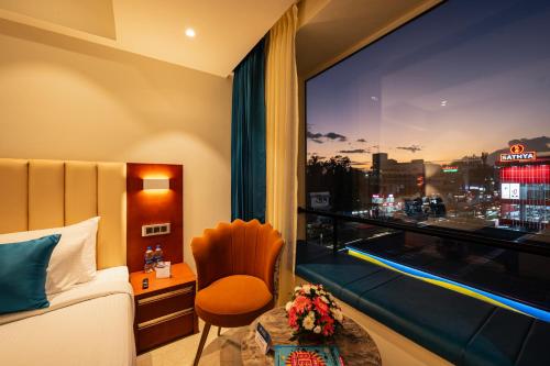 a hotel room with a bed and a window with a view at Hotel Classic Pavilion in Trivandrum