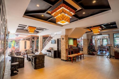 a lobby of a restaurant with chairs and a chandelier at Nipa Resort, Patong Beach in Patong Beach
