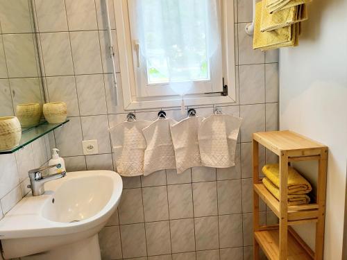 a bathroom with a sink and a toilet and a window at Schöne Gartenwohnung am Strand von Tegna Centovalli in Tegna