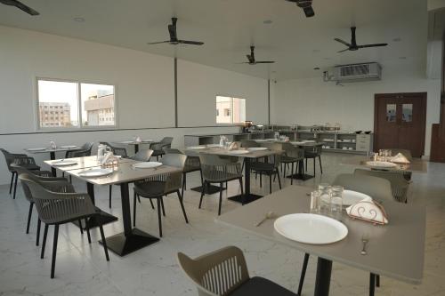 a restaurant with tables and chairs in a room at Manchester Suites in Coimbatore
