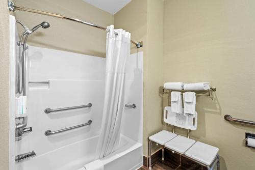 a bathroom with a shower and a bath tub with towels at Quality Inn & Suites Des Moines Airport in Des Moines