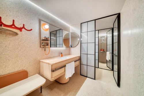 a bathroom with a sink and a mirror at Orange Hotel Hangzhou Songcheng in Hangzhou