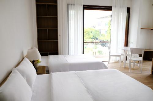 ein Hotelzimmer mit zwei Betten und einem Fenster in der Unterkunft Anna Home Ninh Binh in Kỳ Vĩ