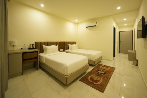 a hotel room with two beds and a desk at Veerdency Luxury Resort - 3 Km to Banglore Airport in Bangalore