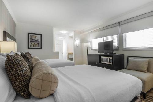 Inn Off Capitol Park, an Ascend Collection Hotel في سكرامنتو: غرفة فندق مع سرير وتلفزيون