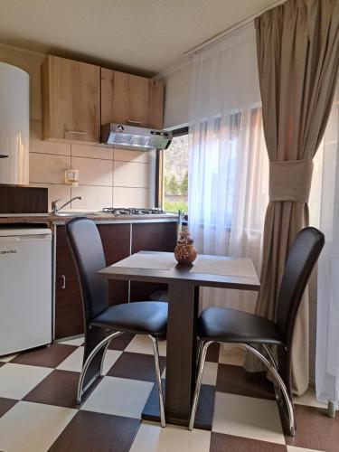 Una pequeña cocina con una mesa y dos sillas. en Shelby Accommodation -Adult Only-, en Sinaia