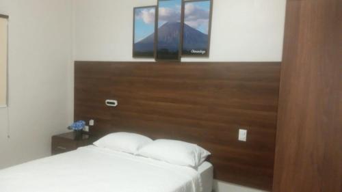 a bedroom with a bed with a large wooden headboard at Hostal Boutique Isabel in Managua