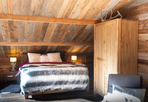 a bedroom with a bed and a wooden ceiling at La sittelle in Belvédère