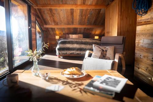 a living room with a table and a bed at La sittelle in Belvédère
