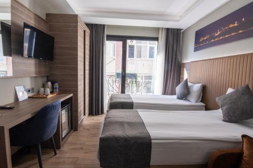 ein Hotelzimmer mit zwei Betten und einem Schreibtisch in der Unterkunft The Omiya Hotel in Istanbul