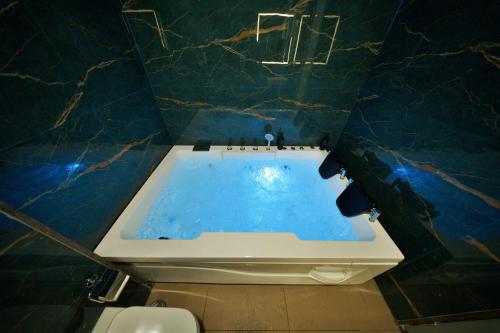 a bathroom with a bath tub in a blue and marble wall at Veerdency Luxury resort in Bengaluru