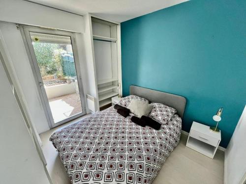サン・ローラン・デュ・ヴァールにあるLe riviera bay avec parkingの青い壁のベッドルーム1室(ベッド1台付)
