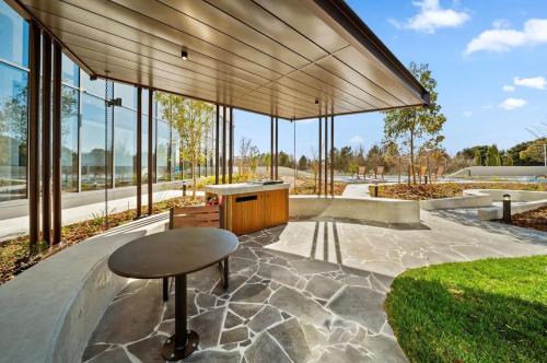 Modern & Stylish Haven Westfield Hospital, gym&Pool, Free P في Phillip: مبنى زجاجي كبير به طاولة ومقعد