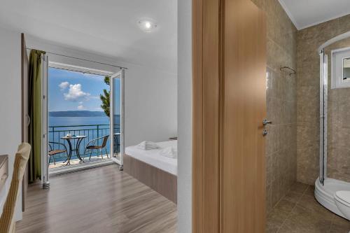a bathroom with a toilet and a balcony with a view at View Blue Apartments in Brela