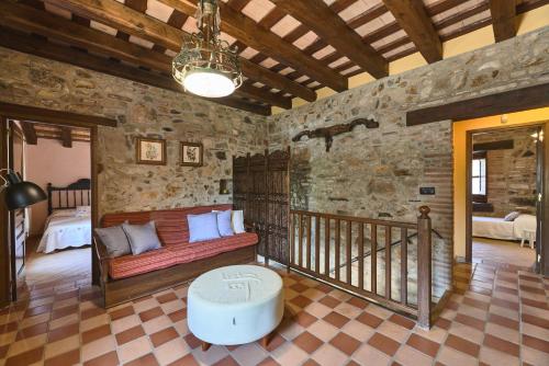 sala de estar con sofá en una pared de piedra en Villa - Can Salarichs, en Riudarenes