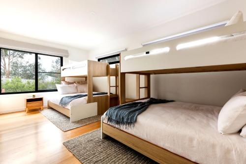 a bedroom with two bunk beds and a large window at Bali Hi Walk to Beach in Balnarring Beach