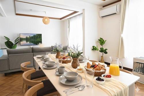 a dining room with a table with food on it at HOSHIYA Kamifurano in Kami-furano