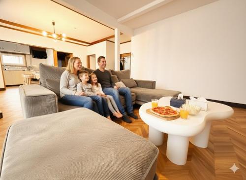 a family sitting on a couch in a living room at HOSHIYA Kamifurano in Kami-furano