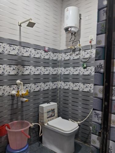 een kleine badkamer met een toilet en een emmer bij Nidhi dham inn in Vrindāvan