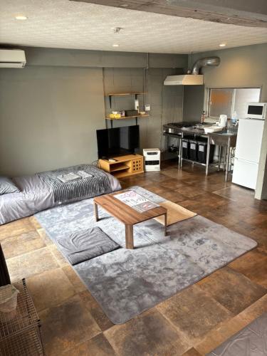 a living room with a table and a kitchen at oak HOUSE in Matsuyama
